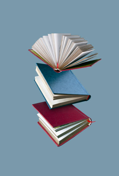 istock books with blue and red binding fly on a blue background 1458859443