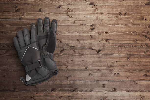 Black winter gloves o an wood background