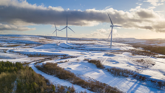 Aerial view of wind turbines on a snow covered hillside in Wales (Bryn Bach)