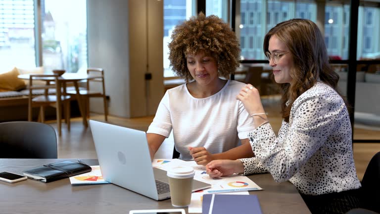 Two business women talking in the office.