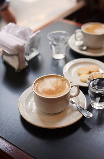 Espresso coffees with steamed milk on a table.