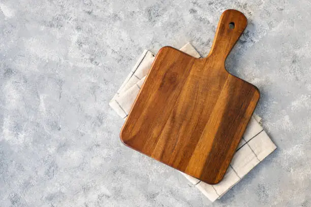 Photo of Cutting board over marble table background. Cooking backdrop. Top view with space for your recipe