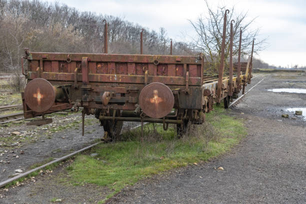 Old rusty industrial freight wagon in an abandoned train station. Train car claimed by nature.