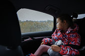 Little girl travelling in car on a rainy day