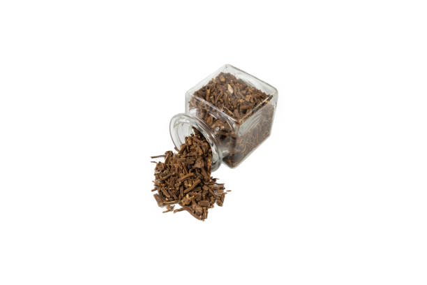 Valerian herb root falling from glass jar isolated on white background. Valeriana officinalis. used in herbal medicine as a tranquillizer and to treat insomnia, anxiety, hypertension, pain relief. raíz de hierba valeriana que cae de un frasco de vidrio aislado sobre fondo blanco. valeriana officinalis. se utiliza en la medicina herbal como tranquilizante y para tratar el insomnio, la ansiedad, la hipertensión, el alivio del dolor.