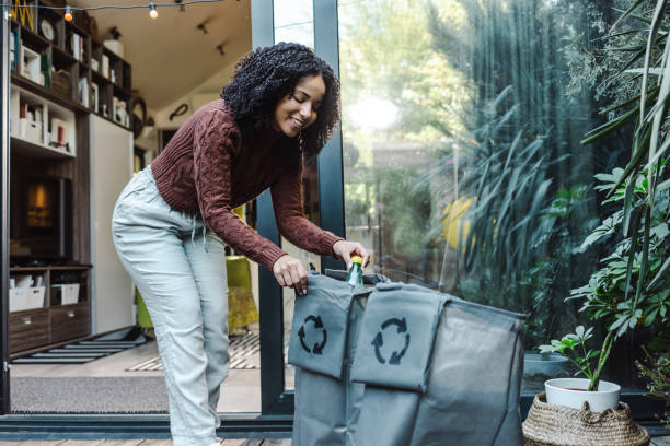 Woman sorts plastic waste in the back yard stock photo