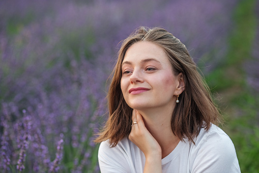 Portrait of a young beautiful woman in a purple field. Close-up