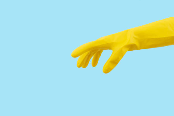istock Hand in yellow rubber glove on blue background. Minimal creative cleaning service concept. 1458891882