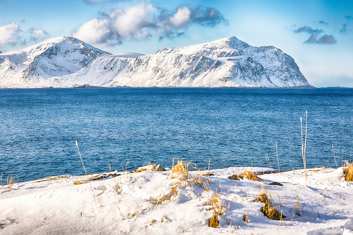 Picturesque winter view on Flakstad coastline seen from the oposite side in the morning. Popular tourist destination. Location: Flakstadoya island, Lofoten; Norway, Europe