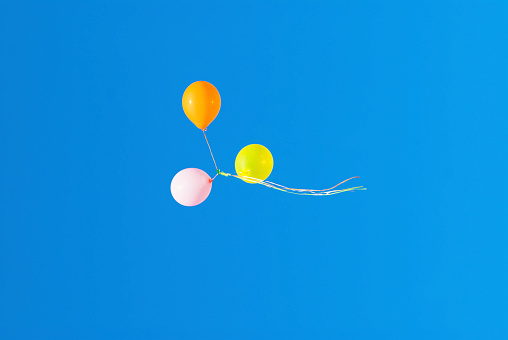 Balloons floating in the air in a background of blue sky