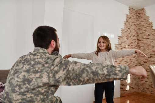 Daughter Running To Embrace Father In Military Uniform On Leave