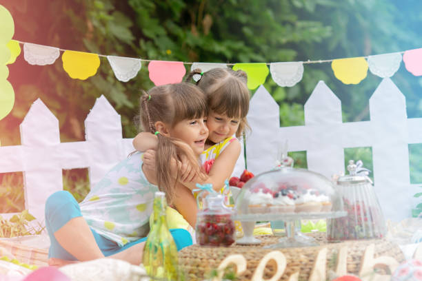 istock Two sisters hugging each other tightly at a summer picnic 1458899276