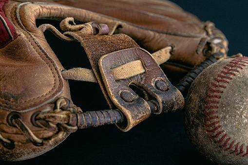 Close-up of a vintage baseball catcher's mitt with a baseball.