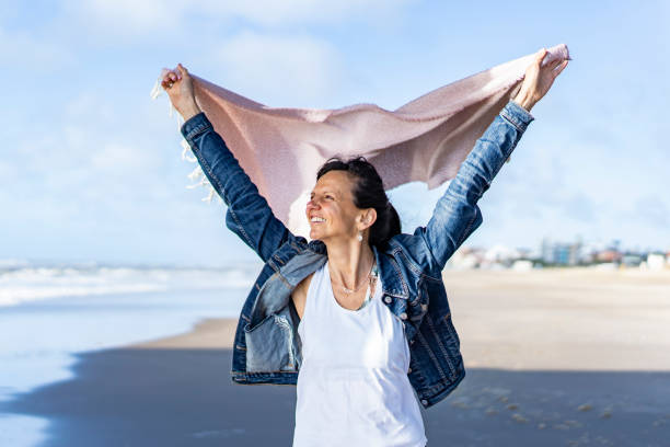 istock Woman walking at the beach while holding a scarf on the wind 1458901285