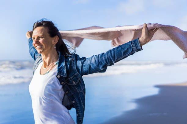 istock Woman walking at the beach while holding a scarf on the wind 1458901315