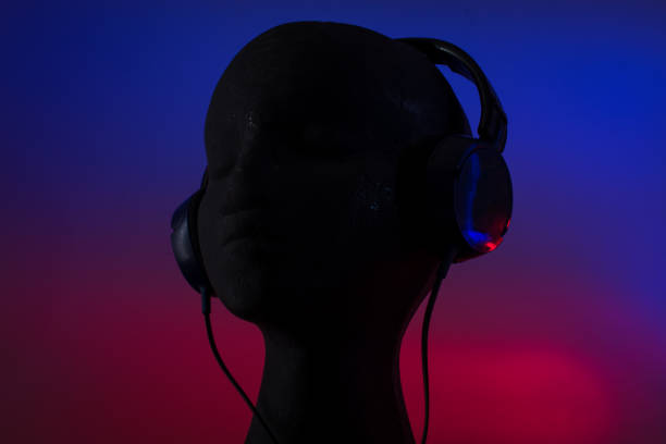 istock Over-ear headphones on black head on blue and red background 1458901637