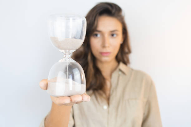 junge frau mit einer sanduhr alternd - charmant stock-fotos und bilder