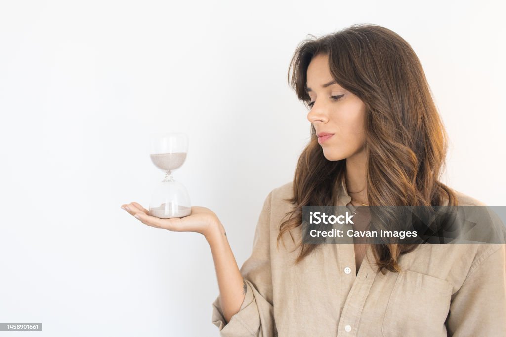 Young Woman Looking at an Hourglass Young Woman Looking at an Hourglass in Lisbon, Lisbon, Portugal 30-34 Years Stock Photo