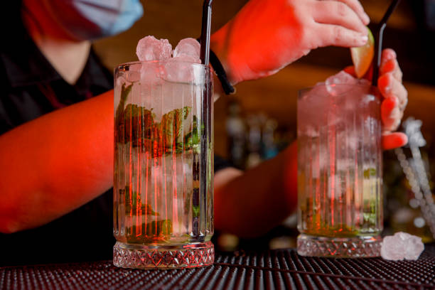 istock young woman bartender makes a cocktail with face mask 1458902147