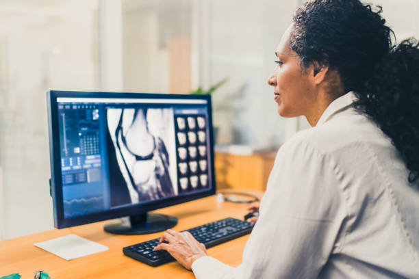 radiologist analysing the images from the mri scan - radiologist imagens e fotografias de stock