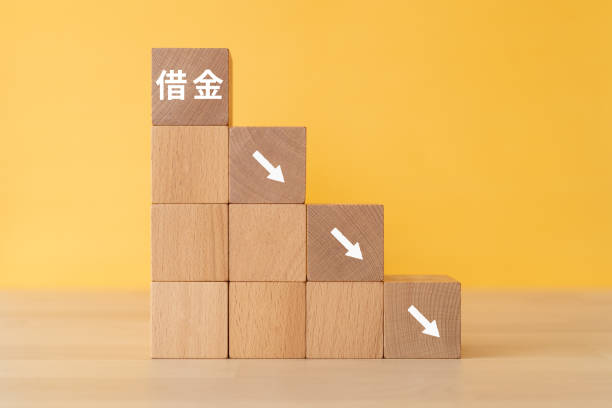istock Wooden blocks with “Debt” text of concept and coins. 1458905346