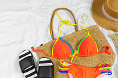 Orange bikini, straw hat for the beach activities. Simple basic summer women clothes. Flat lay. Spring, summer collection of women's clothing, accessories. Casual outfit
