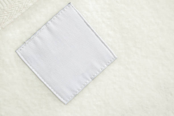 istock Blank white laundry care clothes label on fabric texture background 1458914240