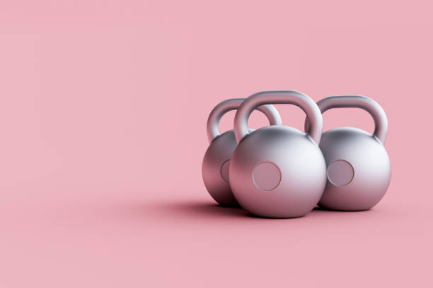 istock Three silver kettlebells isolated on pink background standing close to each other. 1458918680