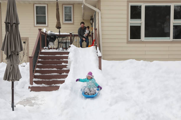 Cheerful father and daughter sledding