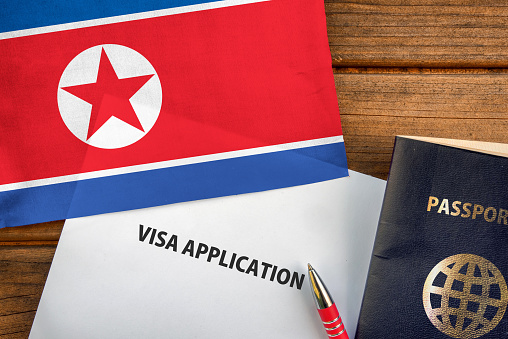 Visa application form, passport and flag of North Korea