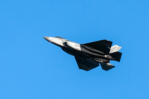 Lockheed Martin F-35 fighter jet in clear blue sky.