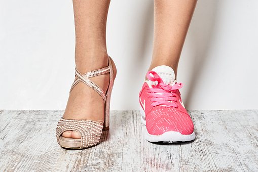 Two different types of shoes on the woman's foots.