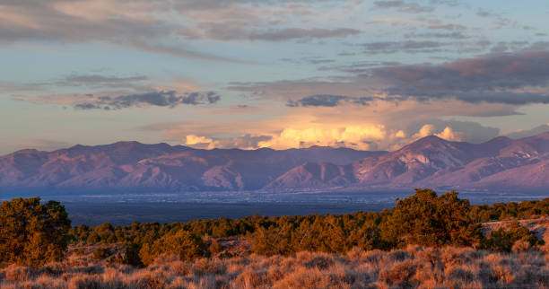Taos Valley, New Mexico at sunset with a thunderstorm developing on the east side of the Sangre de Cristo Mountains.