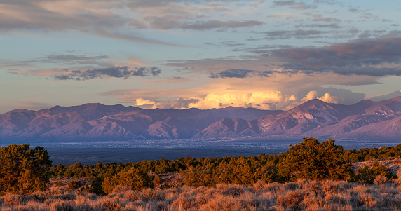 Taos Valley, New Mexico at sunset with a thunderstorm developing on the east side of the Sangre de Cristo Mountains.
