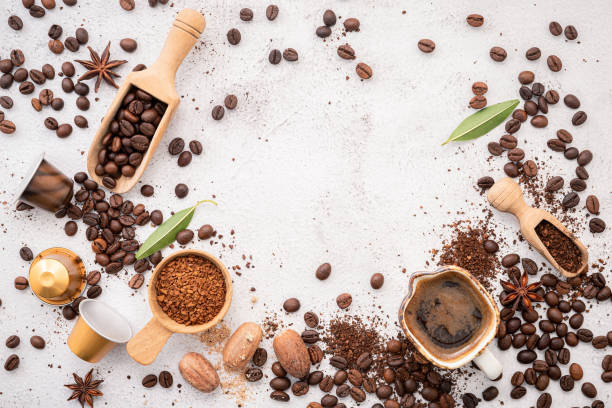 istock Background of various coffee , dark roasted coffee beans , ground and capsules with scoops setup on white concrete background with copy space. 1458944446