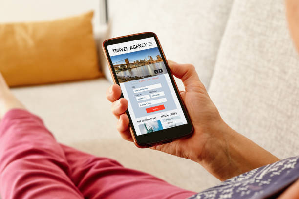 istock Woman on sofa with phone booking a trip online 1458945041