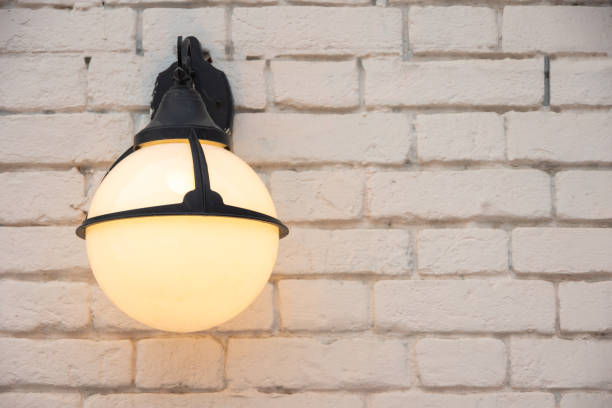 istock A burning round antique lantern on a light brick wall, copy space. circle glass wall lamp on white wall. 1458950756