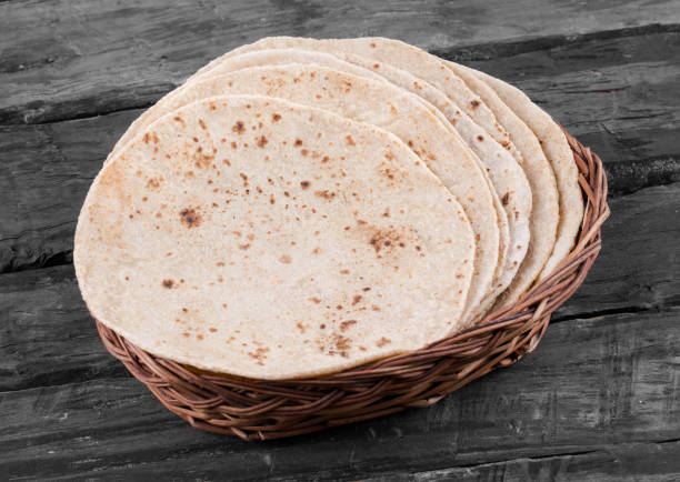 Indian Traditional Cuisine Chapati on Wooden Background Indian Traditional Cuisine Chapati Also Know as Roti, Fulka, Paratha, Indian Bread, Flatbread, Whole Wheat Flat Bread, Chapathi, Wheaten Flat Bread, Chapatti, Chappathi or Kulcha on Wooden Background taftan stock pictures, royalty-free photos & images