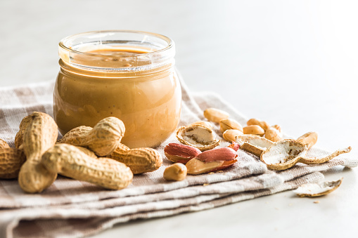 Peanut butter in jar on kitchen table.