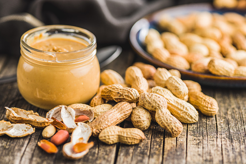 Peanut butter in jar on kitchen table.