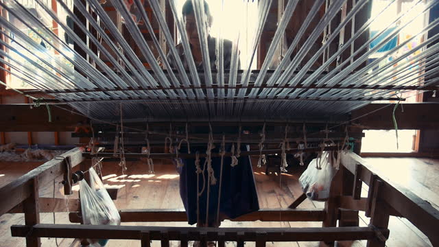Old man weaving on a traditional loom