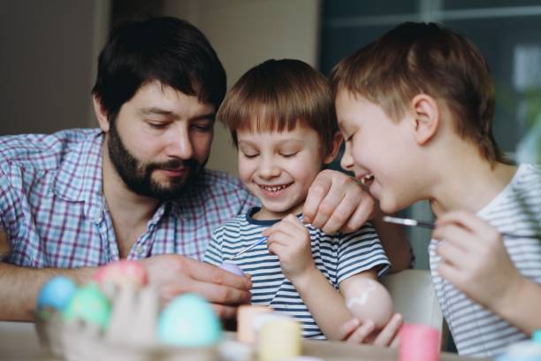 istock father and kids painting eggs for easter 1458984678