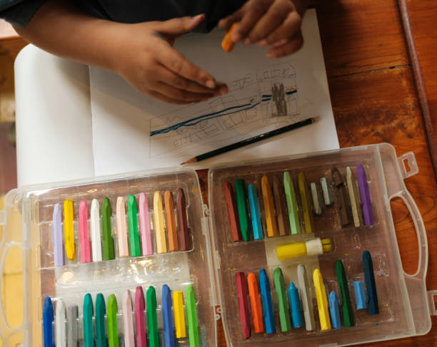 istock a top view of an asian boy while he is drawing using his crayons and pencils on the table, Science, Technology, Education, Mathematics or STEM concept 1458989284