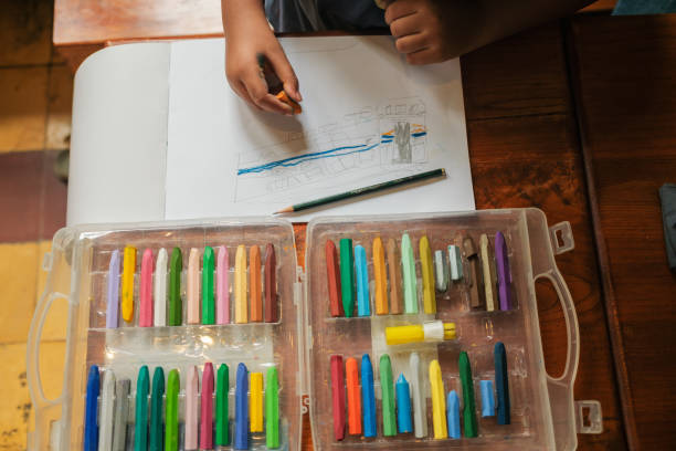 istock a top view of an asian boy while he is drawing using his crayons and pencils on the table, Science, Technology, Education, Mathematics or STEM concept 1458989438