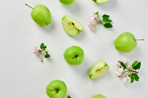 Flat lay Apple flowers and ripe green apples on a white background, Fruits and flowers, sping concept. Top view
