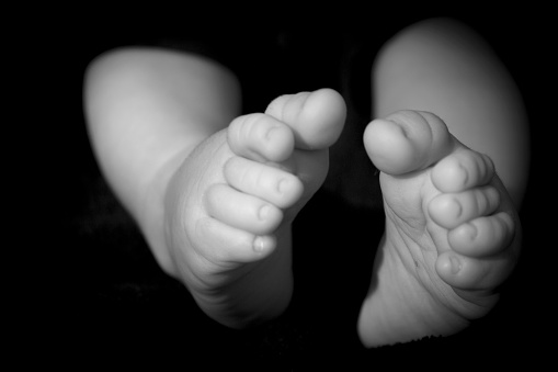 Baby feet on black background. Tranquil scene