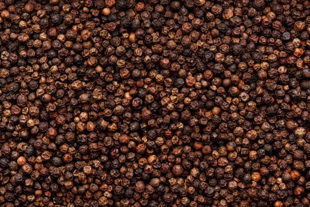 istock Black pepper, peppercorns, dry spice, food background texture, top view 1458998505