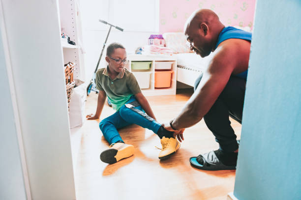 istock father helping his son putting on soccer shoe 1458998745