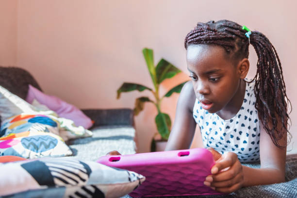 istock little girl looking at digital tablet on sofa 1458998810