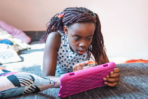 istock little girl looking at digital tablet on sofa 1459000188